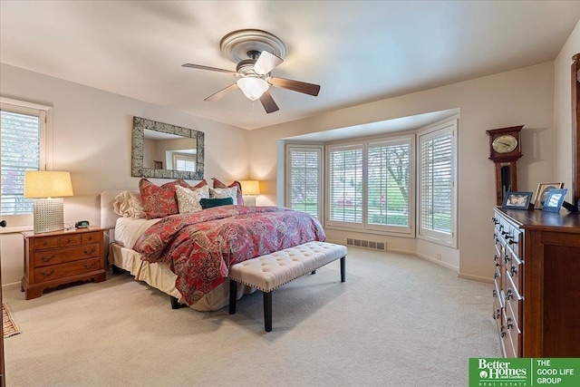 bedroom with baseboards, multiple windows, visible vents, and light colored carpet