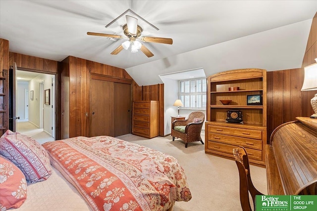 bedroom featuring light colored carpet, wood walls, and a closet