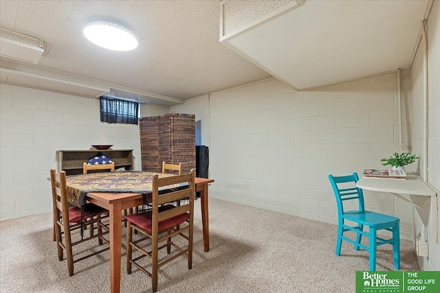 dining area featuring carpet flooring and concrete block wall