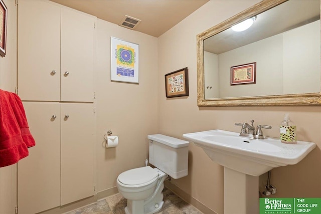 bathroom with toilet, baseboards, visible vents, and a sink