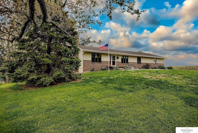 ranch-style house featuring a front lawn and brick siding