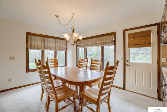 dining space featuring an inviting chandelier, baseboards, and light carpet