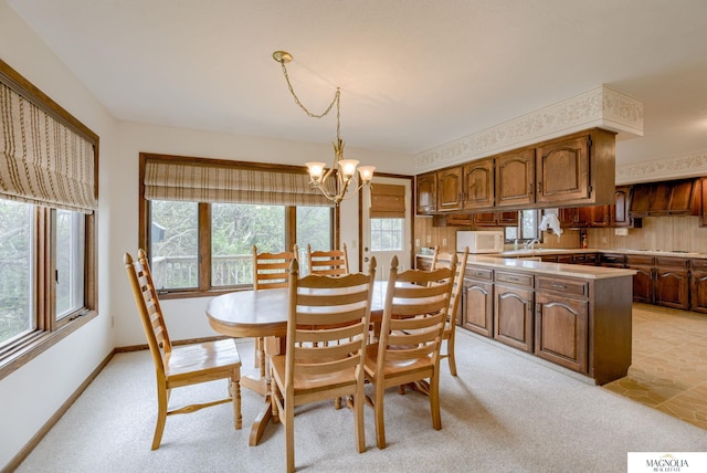 dining space with light colored carpet, baseboards, and a chandelier