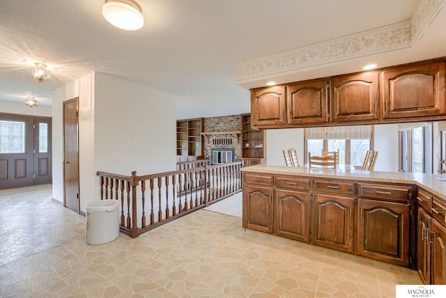 kitchen featuring light countertops, stone finish floor, and a fireplace