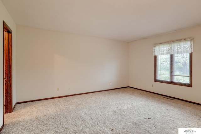 carpeted spare room with baseboards and visible vents