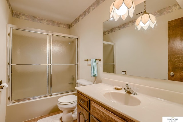 bathroom with vanity, combined bath / shower with glass door, and toilet