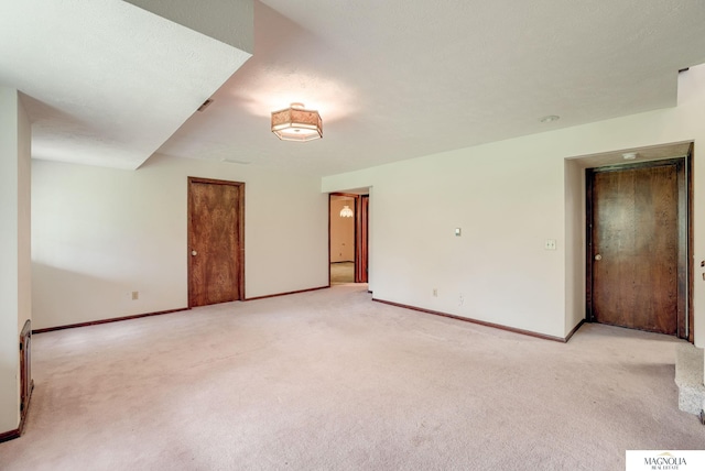 empty room featuring light colored carpet and baseboards