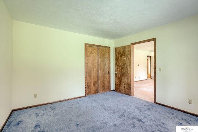 unfurnished bedroom featuring baseboards, carpet, and a closet