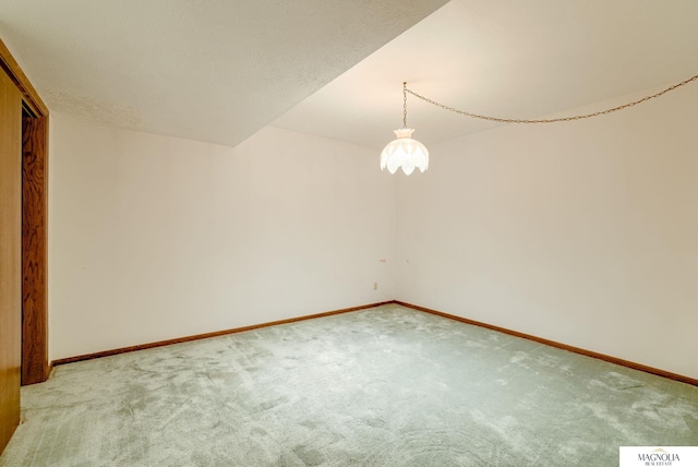 carpeted spare room featuring baseboards