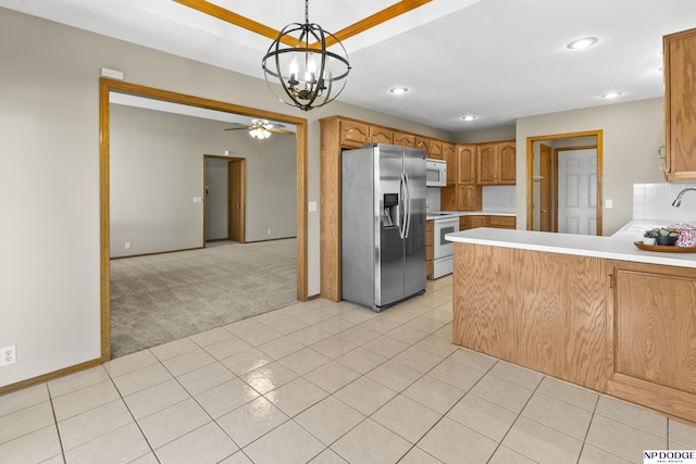 kitchen with light carpet, white appliances, light countertops, ceiling fan with notable chandelier, and a peninsula