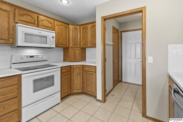 kitchen with white appliances, brown cabinets, decorative backsplash, and light countertops