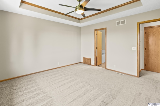 unfurnished room with visible vents, a ceiling fan, and a tray ceiling