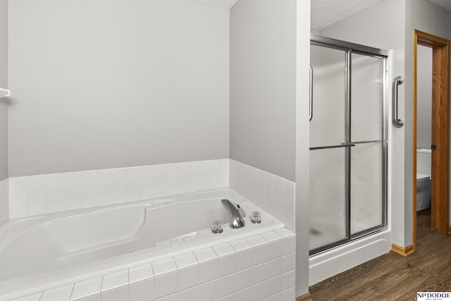 full bath featuring toilet, a shower stall, wood finished floors, and a bath