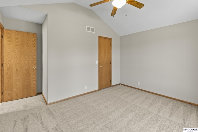 unfurnished bedroom featuring carpet floors, baseboards, vaulted ceiling, and visible vents