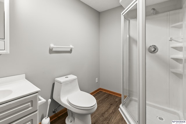 bathroom featuring toilet, a shower stall, and wood finished floors