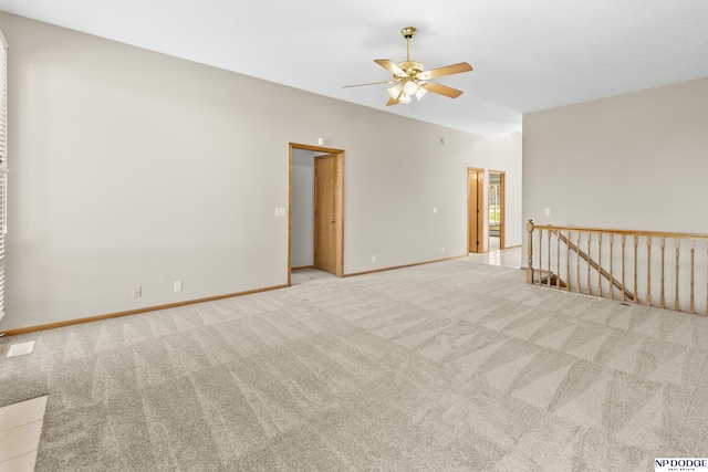 unfurnished room with baseboards, a ceiling fan, and carpet