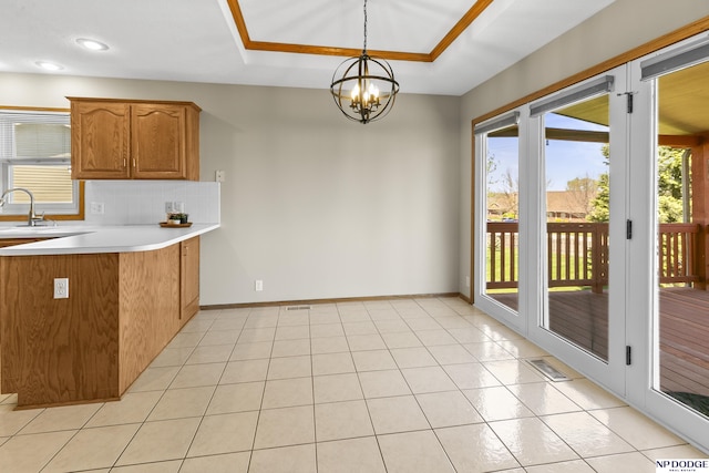 kitchen featuring brown cabinets, a notable chandelier, visible vents, and a wealth of natural light