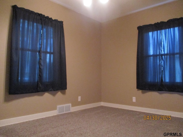 spare room with visible vents, carpet, and baseboards