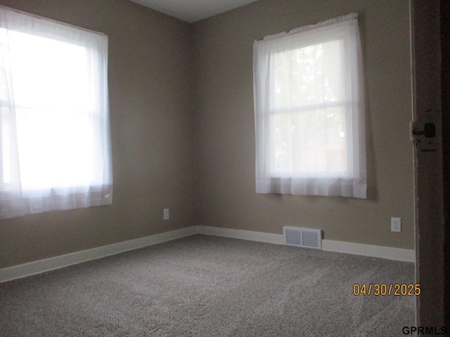 carpeted empty room with baseboards and visible vents