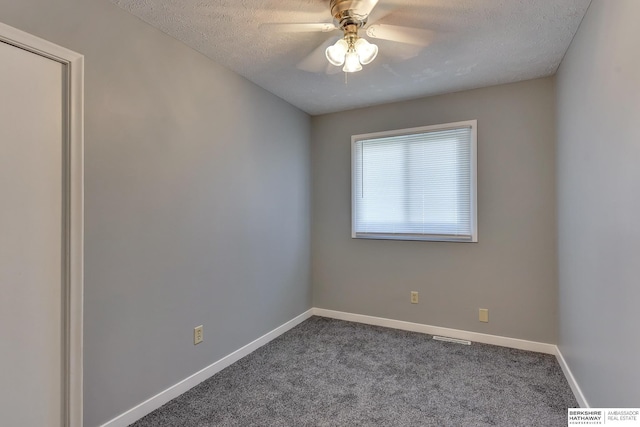 unfurnished room with ceiling fan, carpet flooring, a textured ceiling, and visible vents