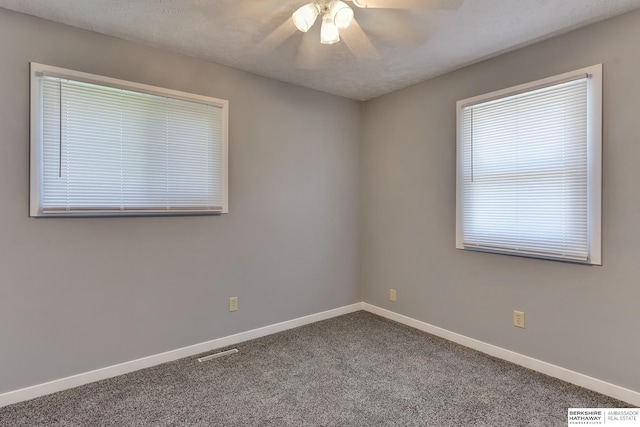 spare room featuring baseboards, a ceiling fan, carpet floors, and visible vents