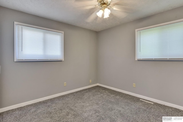 carpeted empty room with a ceiling fan, baseboards, and visible vents