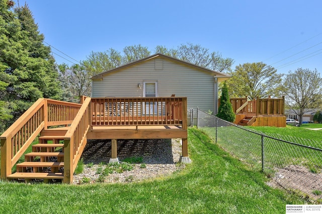 back of property with stairs, a fenced backyard, a wooden deck, and a yard