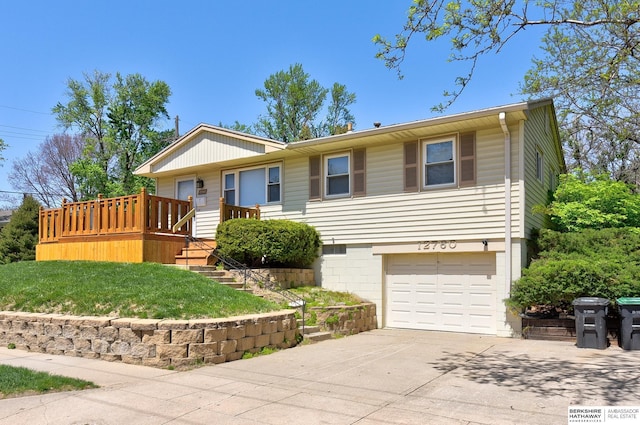 ranch-style house with stairway, a deck, concrete driveway, and a garage