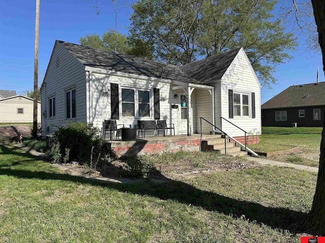 bungalow-style house with a front yard, a porch, and a shingled roof