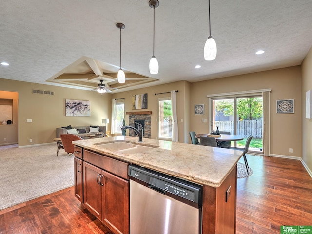kitchen featuring a textured ceiling, visible vents, dishwasher, a sink, and open floor plan