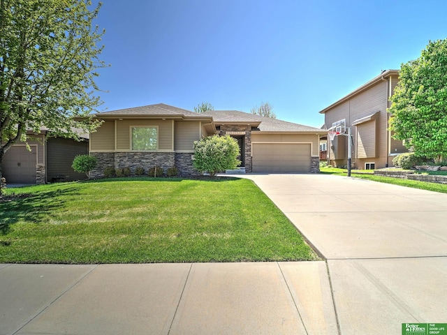 prairie-style home featuring an attached garage, a front yard, driveway, and stone siding