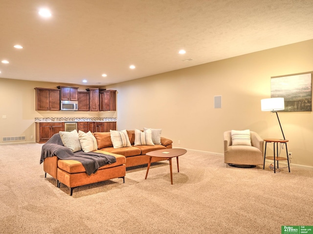 living area with baseboards, light colored carpet, recessed lighting, and visible vents
