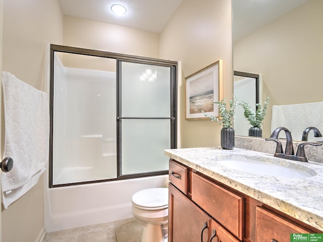bathroom featuring toilet, combined bath / shower with glass door, tile patterned flooring, and vanity