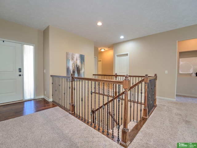 hall with baseboards, carpet, recessed lighting, and an upstairs landing