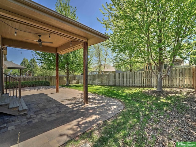 view of yard with ceiling fan, a fenced backyard, and a patio area