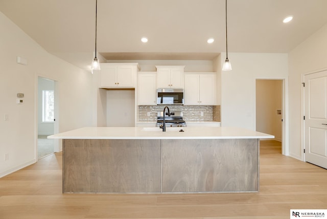16014 Daniel St, Bennington, NE 68007 - kitchen with appliances with stainless steel finishes, a sink, light countertops, backsplash, and a center island with sink