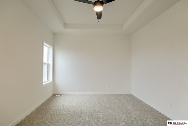16014 Daniel St, Bennington, NE 68007 - unfurnished room with carpet flooring, a ceiling fan, baseboards, and a tray ceiling
