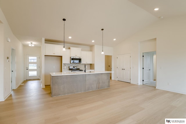 16014 Daniel St, Bennington, NE 68007 - kitchen with white cabinets, light wood-style floors, light countertops, stainless steel appliances, and tasteful backsplash