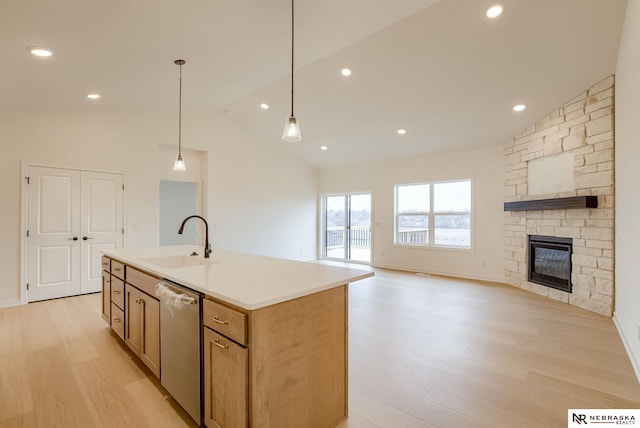 16014 Daniel St, Bennington, NE 68007 - kitchen featuring stainless steel dishwasher, a sink, light wood finished floors, open floor plan, and an island with sink