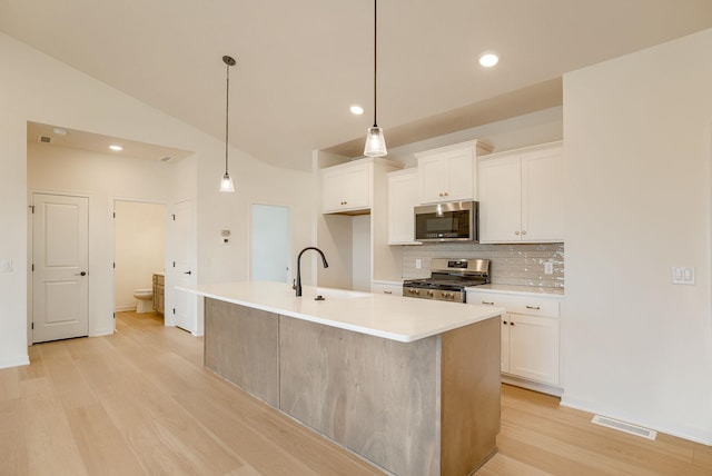 16014 Daniel St, Bennington, NE 68007 - kitchen with backsplash, appliances with stainless steel finishes, white cabinetry, a sink, and light wood-style flooring