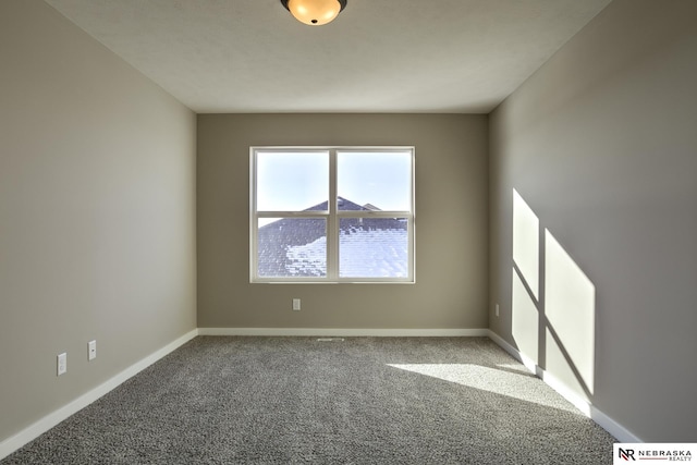 spare room featuring baseboards and carpet flooring