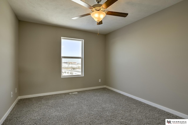 carpeted spare room featuring baseboards, ceiling fan, and visible vents