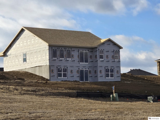 back of property with a shingled roof