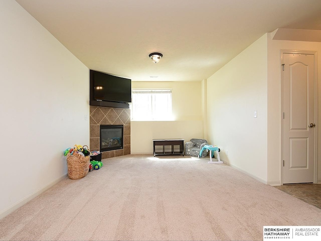 unfurnished living room featuring carpet flooring, baseboards, and a tile fireplace