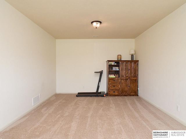 unfurnished room featuring baseboards, visible vents, and carpet