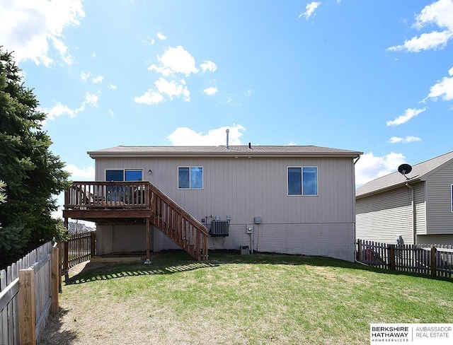 rear view of house featuring a fenced backyard, a wooden deck, a yard, and stairway
