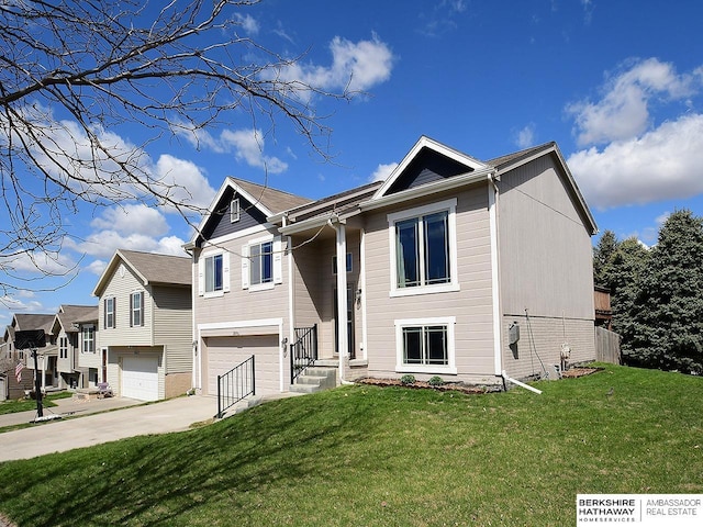 split foyer home featuring a garage, driveway, and a front lawn