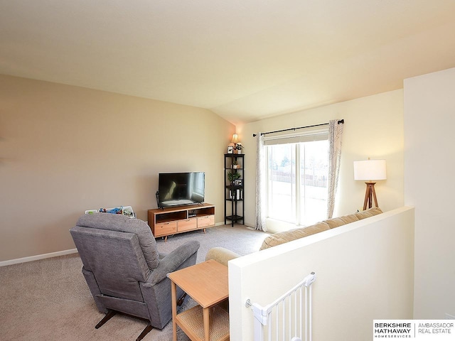 living area featuring vaulted ceiling, baseboards, and carpet flooring