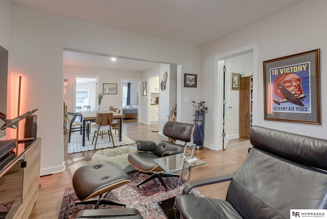 living area featuring light wood-style floors and baseboards