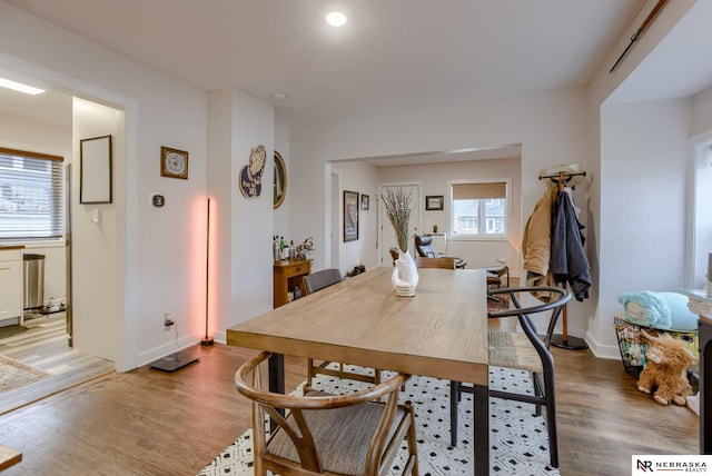 dining space featuring baseboards and light wood-style floors
